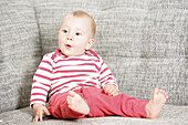 Baby sitting on a sofa