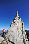Junge Frau sichert Kletterer an Felsturm, Kampenwand, Chiemgauer Alpen, Chiemgau, Oberbayern, Bayern, Deutschland