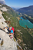 Young man climbing fixed rope route Rino Pisetta, Lago die Toblino, Sarche, Calavino, Trentino, Trentino-Alto Adige, Suedtirol, Italy