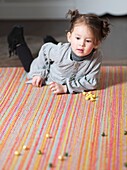 Little girl playing on the carpet