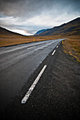 Open Road Among Mountains Under Dramatic Cloudy Sky, Iceland