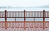 A wooden boardwalk and railings, on the shores of a lake. Mist rising from the water. Dawn or dusk., Lake, Taiwan, Asia.