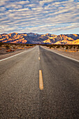 Sunrise. A paved road in Death Valley National Park. The hottest, driest and lowest spot in North America., Paved road in Death Valley National Park, sunrise