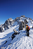 Frau auf Skitour steht in Scharte Schweizer Tor, Blick auf Drusenfluh, St. Antönien, Prättigau, Graubünden, Schweiz