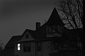 Old House at Night With One Window Illuminated