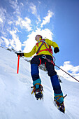 Mountaineer ascending with crampons and ice axe, Piz Palue, Grisons, Switzerland