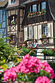 Mother and daughters in front of half-timbered houses in Petite Venise, Colmar, Alsace, France