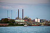 Rhine river and Bayer chemical and pharmaceutical company factory chimneys at dusk, Leverkusen, North Rhine-Westphalia, Germany, Europe