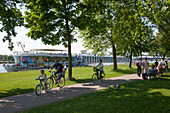 Familie auf Fahrrädern passiert das Flusskreuzfahrtschiff MS Bellevue, Kehl, Baden-Württemberg, Deutschland, Europa