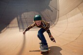 Young teenager skateboarding in a bowl