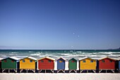 Colorful beach huts at the sandy beach of Muizenberg with blue sky, seen from above with seagulls, False Bay near Cape Town, South Africa