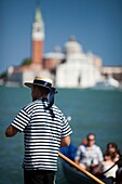 Gondolier at work in front of San Giorgio Maggiore, Venice, Italy
