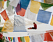 Mönch Wangyal betet auf Khardung La, weiht Gebetsfahnen, 5570 m, höchster befahrbarer Pass und höchste Straße der Welt, nördlich vom Leh, Ladakh, Jammu und Kashmir, Indien