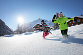 Zwei Kinder rennen im Schnee, Gargellen, Montafon, Vorarlberg, Österreich