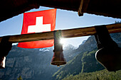 Schweizer Fahne und Kuhglocken am Oeschinensee, Kandersteg, Berner Oberland, Kanton Bern, Schweiz, Europa