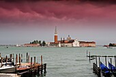 Gondolas and Taxi Pier front of Piazza di San Marco with San Giorgio Maggiore Isola di photographed with a filter mauve gradient in the sky, Venice, Italy