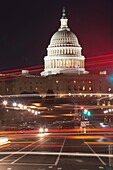 Traffic crossing Pennsylvania avenue creates light streaks with the Capitol dome in the background in Washington, DC, USA