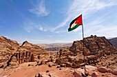 Jordanian flag flying in front of the Monastery, sculpted out of the rock, at Petra, Jordan