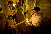 A boy makes a wax ball using a candle during an Easter Holy Week procession in Cordoba, Andalusia, Spain, April 20, 2011