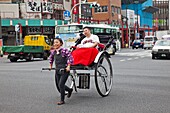 Japan,Tokyo,Asakusa,Female Rickshaw Porter transporting Overweight Male Passenger