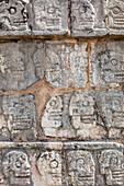 Tzompantli or Platform of the skulls. The skulls of enemies killed in battle or sacraficed were placed on the walls in the pre-Columbian or Mayan civilization. Carvings. Archaeological site.