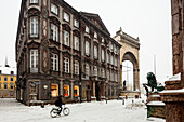 Feldherrnhalle, Odeonsplatz and lion statue, bicyclist at night in snow drift, Munich, Bavaria, Germany