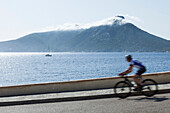 Bicycle rider at the Mediterranean coast, island of Dragonera in background, Sant Elm, Majorca, Balearic Islands, Spain