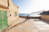 Bicycle rider at the Mediterranean coast, Sant Elm, Majorca, Balearic Islands, Spain