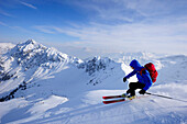 Young man downhill skiing from mount Sulzspitze, Tannheim Mountains, Allgaeu Alps, Tyrol, Austria