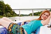 Junge Frau liegt in einem Schlauchboot an der Isar, München, Bayern, Deutschland