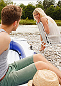 Young couple on the Isar riverbank, Munich, Bavaria, Germany