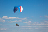 Paraglider in front of clouded sky