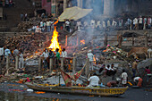 Das Feuer einer Verbrennung von Leichen am Manikarnika Ghat am Ufer des Fluss Ganges, Varanasi, Uttar Pradesh, Indien