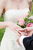 Groom putting wedding ring on bride
