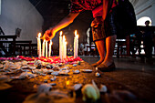 Woman Lighting Candles in Church