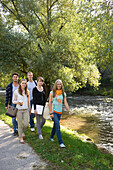 Gruppe junger Leute läuft am Ufer der Dreisam entlang, Freiburg im Breisgau, Schwarzwald, Baden-Württemberg, Deutschland