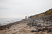 Pebbbles beach with fisherman in the rain, Baltic Sea, beach near Bakenberg, Wittow Peninsula, Island of Ruegen, Mecklenburg West-Pomerania, Germany