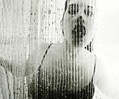 Woman With Mouth Open Behind Netted Curtain