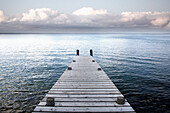 A wooden jetty reaching out into the waters of Lake Taupo.
