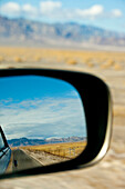 A car driving through the desert landscape, Reflection of the landscape in the car wing mirror