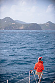 Frau sitzt am Bug von einem Boot, Karibik