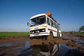 Bus driving through mud on a bad road, Madagascar