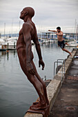 Waterfront with statue Max Patte's Solace of the Wind and swimmer, Wellington, North Island, New Zealand