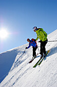Two backcountry skiers downill skiing from mount Brechhorn, Kitzbuehel Alps, Tyrol, Austria