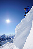 Skifahrer auf Schneewechte macht sich zur Abfahrt bereit, Großer Rettenstein im Hintergrund, Brechhorn, Kitzbüheler Alpen, Tirol, Österreich