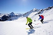 Zwei Skitourengeher fahren vom Brechhorn ab, Großer Rettenstein im Hintergrund, Kitzbüheler Alpen, Tirol, Österreich