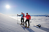 Two backcountry skiers ascending to notch Rote-Rinn-Scharte, hut Gruttenhuette in background, Kaiser-Express, Rote-Rinn-Scharte, Wilder Kaiser, Kaiser mountain range, Tyrol, Austria
