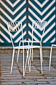 Two white garden chairs in front of the striped wall, Vienna, Austria