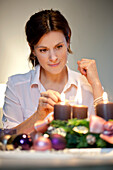Mid adult woman lighting candles on an Advent wreath