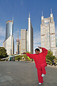 Older woman practicing sword fighting techniques in Lujiazui Park, Oriental Pearl Tower, Pudong, Shanghai, China